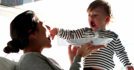 Téléchargez les photos : Baby boy feeding mother food, funny toddler child feeds parent - en image libre de droit