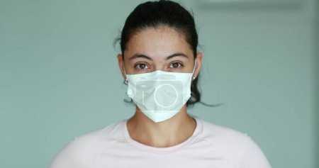 Téléchargez les photos : Woman putting face mask to protect from virus - en image libre de droit