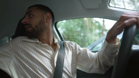 Téléchargez les photos : Un Arabe qui met sa ceinture et s'en va. Un chauffeur moyen-oriental assis à l'intérieur du véhicule et conduisant - en image libre de droit