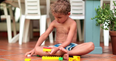 Téléchargez les photos : Enfant jouant avec les blocs de construction. Bloc de construction pour bébé tout-petit enfant - en image libre de droit