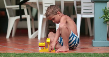 Téléchargez les photos : Enfant jouant avec des blocs jouet à l'extérieur - en image libre de droit