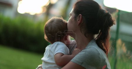 Téléchargez les photos : Parent consolant bébé bébé dehors dans le jardin - en image libre de droit