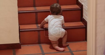 Photo for Baby climbing and standing on home stairs - Royalty Free Image