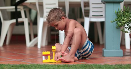 Téléchargez les photos : Enfant jouant avec des blocs jouet à l'extérieur - en image libre de droit