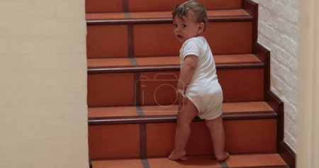 Foto de Baby climbing and standing on home stairs - Imagen libre de derechos