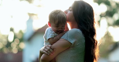 Téléchargez les photos : Mère et bébé ensemble pendant le coucher du soleil heure dorée dehors - en image libre de droit