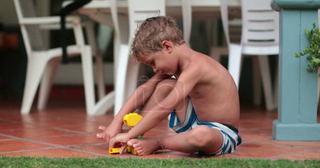 Foto de Niño pequeño bebé jugando al aire libre con juguetes - Imagen libre de derechos