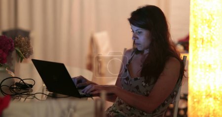 Téléchargez les photos : Femme travaillant tard dans la nuit devant l'écran d'ordinateur portable - en image libre de droit