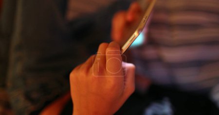 Téléchargez les photos : Gros plan de l'appareil tablette tenant la main de l'enfant la nuit jouer au jeu - en image libre de droit