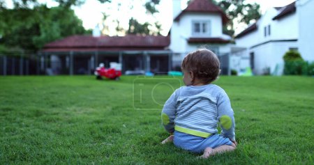 Téléchargez les photos : Beau bébé enfant rampant à l'extérieur sur l'herbe - en image libre de droit