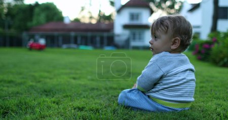 Téléchargez les photos : Bébé bébé rampant à l'extérieur dans la maison jardin herbe - en image libre de droit