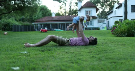 Foto de Padre vinculación con bebé bebé hijo en jardín casero al aire libre - Imagen libre de derechos