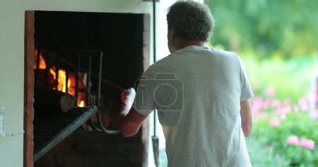 Foto de Hombre mayor preparando barbacoa a la parrilla en casa, franca vida real senior jubilado cocinar - Imagen libre de derechos