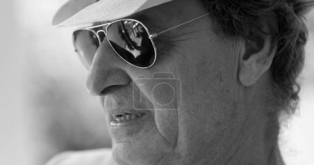 Téléchargez les photos : Close-up older man face wearing sunglasses and hat in artistic black and white - en image libre de droit
