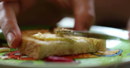 Téléchargez les photos : Étaler le beurre sur le pain grillé close-up - en image libre de droit