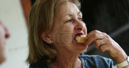 Photo for Senior woman eating breakfast toast with jelly - Royalty Free Image