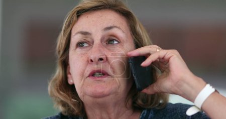 Téléchargez les photos : Candid casual senior woman speaking with smartphone conversation - en image libre de droit
