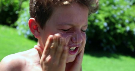 Téléchargez les photos : Visage d'enfant frottant les mains à l'extérieur - en image libre de droit