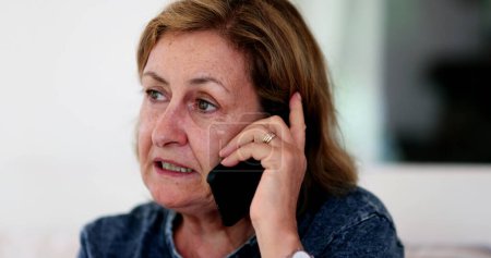 Téléchargez les photos : Older woman in 60s speaking over the phone - en image libre de droit