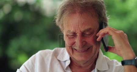 Téléchargez les photos : Happy older man speaking with friend on cellphone - en image libre de droit