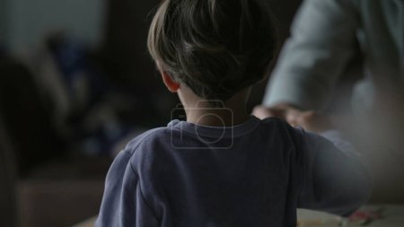 Foto de Detrás del niño jugando con juegos de mesa madre en casa. Educación en el hogar en la infancia estilo de vida - Imagen libre de derechos