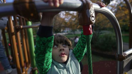 Photo for Active little kid holding into metal bar at playground outside during autumn season. Child exercises outdoors closeup hands - Royalty Free Image