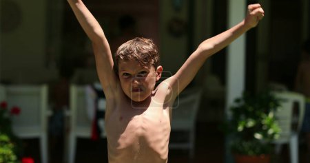 Photo for Child raising arms in the air in celebration. Excited young boy raises arm celebrating - Royalty Free Image