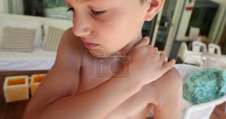 Téléchargez les photos : Écran solaire de propagation de l'enfant à la peau du corps - en image libre de droit