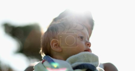 Photo for Baby child wrapped in towel after pool in sunlight - Royalty Free Image