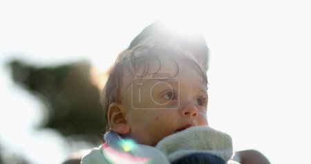 Photo for Baby child wrapped in towel after pool in sunlight - Royalty Free Image