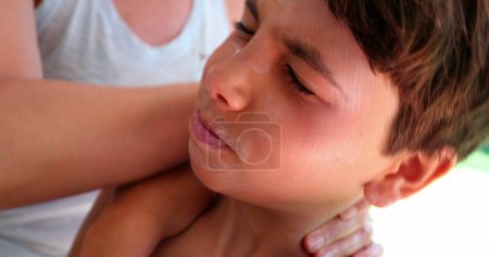 Photo for Mother applying sunblock lotion to child boy face. Mom applies sunscreen rubbing suncream to son face - Royalty Free Image