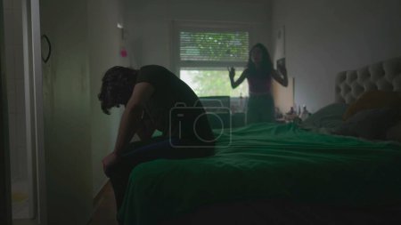 Photo for Relationship in Crisis. Young Couple on the Verge of Breakup, with Male Partner Being Bullied and Screamed at by Female in Background - Royalty Free Image