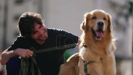 Téléchargez les photos : Propriétaire de chien mâle caressant son Golden Retriever. Homme dans la trentaine souriant avec Pet compagnon - en image libre de droit