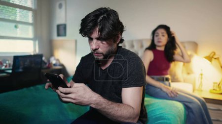 Foto de Hombre joven ignorando a la mujer mientras usa el dispositivo de teléfono inteligente. Pareja en crisis debido a la tecnología moderna. Novia ignorada por novio - Imagen libre de derechos