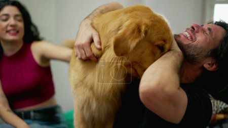 Photo for Happy Male dog owner interacting with playful Golden Retriever Pet indoors. Real life authentic Dog lover relationship - Royalty Free Image