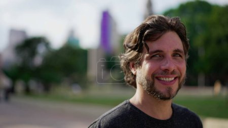 Photo for Young man close-up face standing in city park smiling at camera. A handsome male caucasian person in 30s portrait - Royalty Free Image