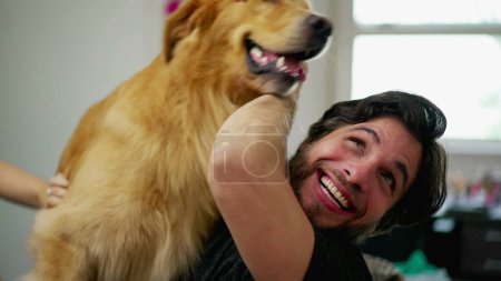 Foto de Dueño de perro macho feliz interactuando con juguetón Golden Retriever Pet en el interior. Vida real auténtica relación amante del perro - Imagen libre de derechos