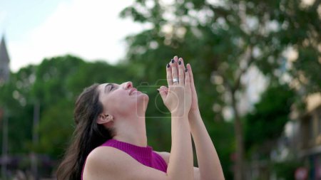 Téléchargez les photos : Jeune femme enthousiaste regardant le ciel ressentir la grâce de Dieu. Femme croyante se sentant reconnaissante et la Foi lève les bras vers le ciel se sentant GRATITUDE - en image libre de droit