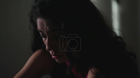 Foto de Mujer joven frágil luchando con la enfermedad mental en la habitación dar. Persona femenina de 30 años sintiéndose sola y sola mientras sufre de depresión - Imagen libre de derechos