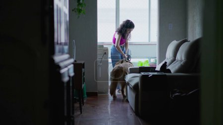 Foto de Mujer saliendo del apartamento con su perro con correa. Persona cándida saliendo a dar un paseo con Golden Retriever PET - Imagen libre de derechos