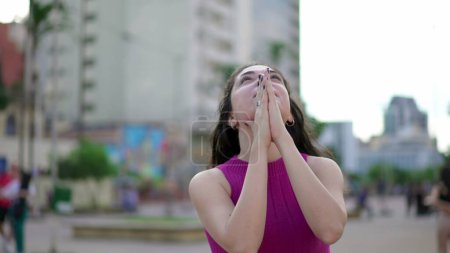 Téléchargez les photos : Jeune femme enthousiaste regardant le ciel ressentir la grâce de Dieu. Femme croyante se sentant reconnaissante et la Foi lève les bras vers le ciel se sentant GRATITUDE - en image libre de droit