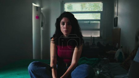 Photo for Loneliness. Young Woman in Solitude inside a Somber bedroom, Her Expression a Reflection of Her Inner Turmoil - Royalty Free Image