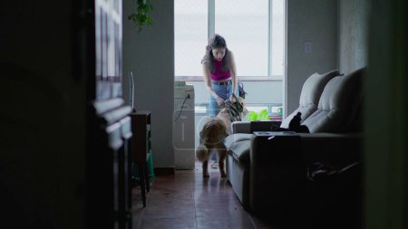 Téléchargez les photos : Femme quittant l'appartement avec son chien en laisse. Personne franche sortir pour une promenade avec Golden Retriever PET - en image libre de droit