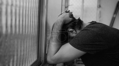 Foto de Hombre luchando con la depresión en casa. Dramático monocromático negro y blanco hombre que sufre de enfermedad mental - Imagen libre de derechos