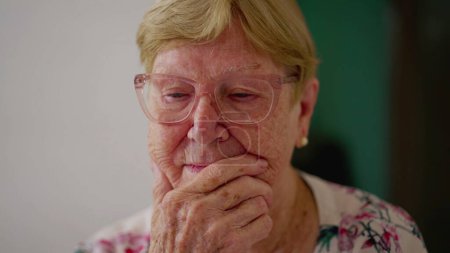 Foto de Mujer anciana pensativa sopesando solución. Una persona mayor caucásica en los 80 contemplando la emoción de cerca la cara con la mano en la barbilla pensando - Imagen libre de derechos