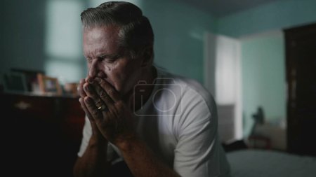 Photo for Desperate senior man covering face suffering from despair and lonliness. Older middle-aged person covering face in shame, struggling with anxiety and mental illness - Royalty Free Image