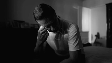 Photo for Monochrome Depiction of Middle-Aged Man Covering Face in Shame, Displaying Despair and Solitude in a Dramatic Black and White Scene - Royalty Free Image