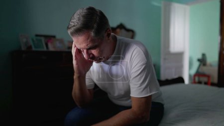 Photo for Anxious preoccupied older man sits by bedside feeling worry. Stressed desperate middle-aged person feeling suffering from mental illness - Royalty Free Image