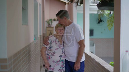 Photo for Adult son kissing senior mother in forehead while posing together, elderly care-taking with arm around elderly parent - Royalty Free Image