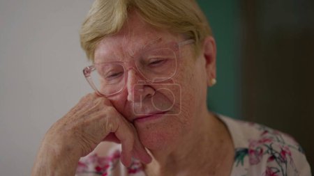 Téléchargez les photos : Femme âgée contemplative rappelant des souvenirs passés. Personne âgée dans les années 80 rêvant, triste mélancolie émotion de dame plus âgée gros plan visage - en image libre de droit